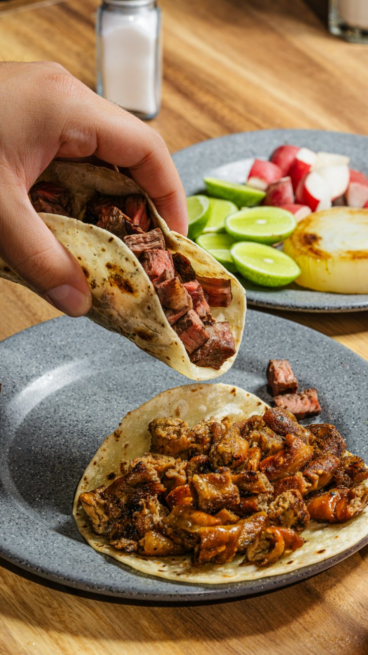 Taco de asada y taco al pastor con limón, rábano y cebolla