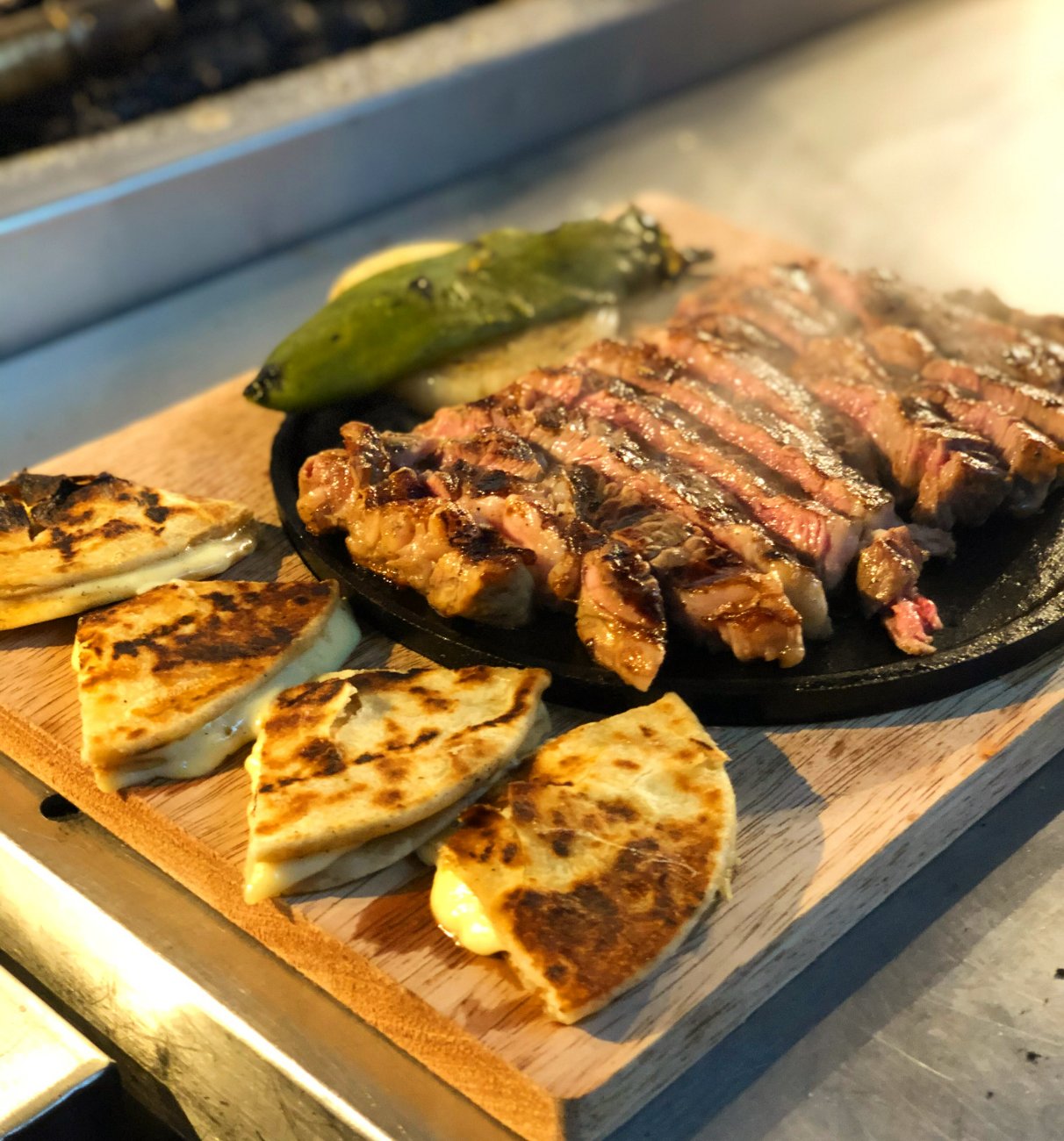 Quesadillas doradas con filete de cabrería en tabla de madera